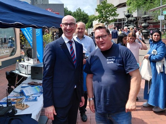 Uetersens Bürgermeister Dirk Woschei und Franky (DJ1FK) vor dem M21-Stand beim Rosenfest.